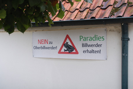 Getrübte Dorfidylle: Plakat an einem Haus in Billwerder, Foto: (c) Reinhard Schwarz/stahlpress